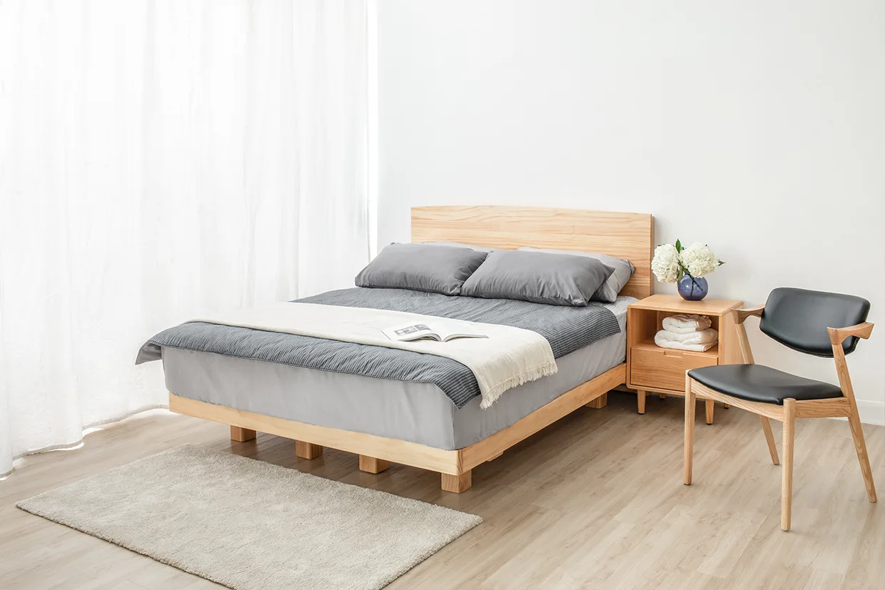 實木Læsø萊斯漂浮床架，搭配灰色調床包及枕頭，右側擺放HOHO喜迎床頭櫃及 Z Chair北歐宮崎椅。