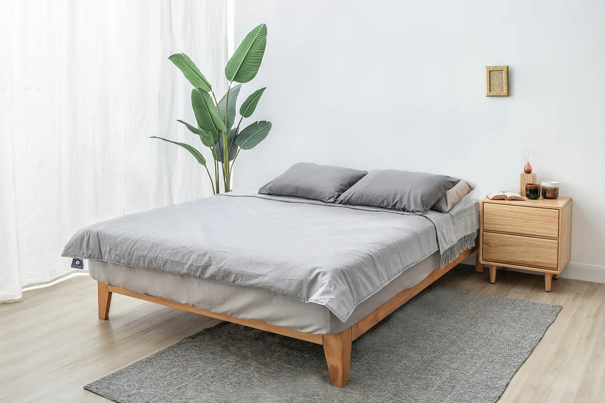 實木Nordic北歐床架，搭配深灰色枕頭及灰色調床包，右側擺放小Sweet八床頭櫃。